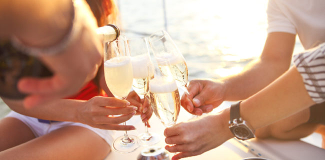 Happy friends with glasses of champagne on yacht. Vacation, trav Happy friends with glasses of champagne on yacht. Vacation, travel, sea and friendship concept. Closeup.